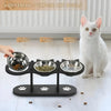 Drei verschiedene Katzenschüsseln für Futter, Leckerli und Wasser auf einem schwarzen Essgefäß.