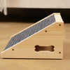 A light wood pet stair ramp with textured gray non-slip steps resting on a wooden surface.