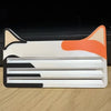 A reusable cat food pouch scraper with a white and orange design, featuring a curved shape and multiple blades.