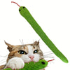 Grüner, gekräuselter Spielzeug in Katzenform wird von einer Hauskatze gespielt.