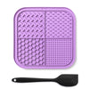 A purple silicone lick mat for dogs and cats with suction cups and a black spoon.