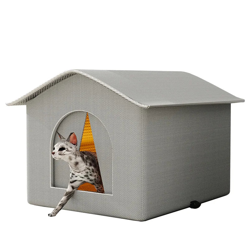 A gray pet house with a pitched roof and an arched entrance, featuring a cat peering out.