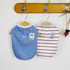 A striped cooling vest for dogs or cats hanging on a wooden rack.