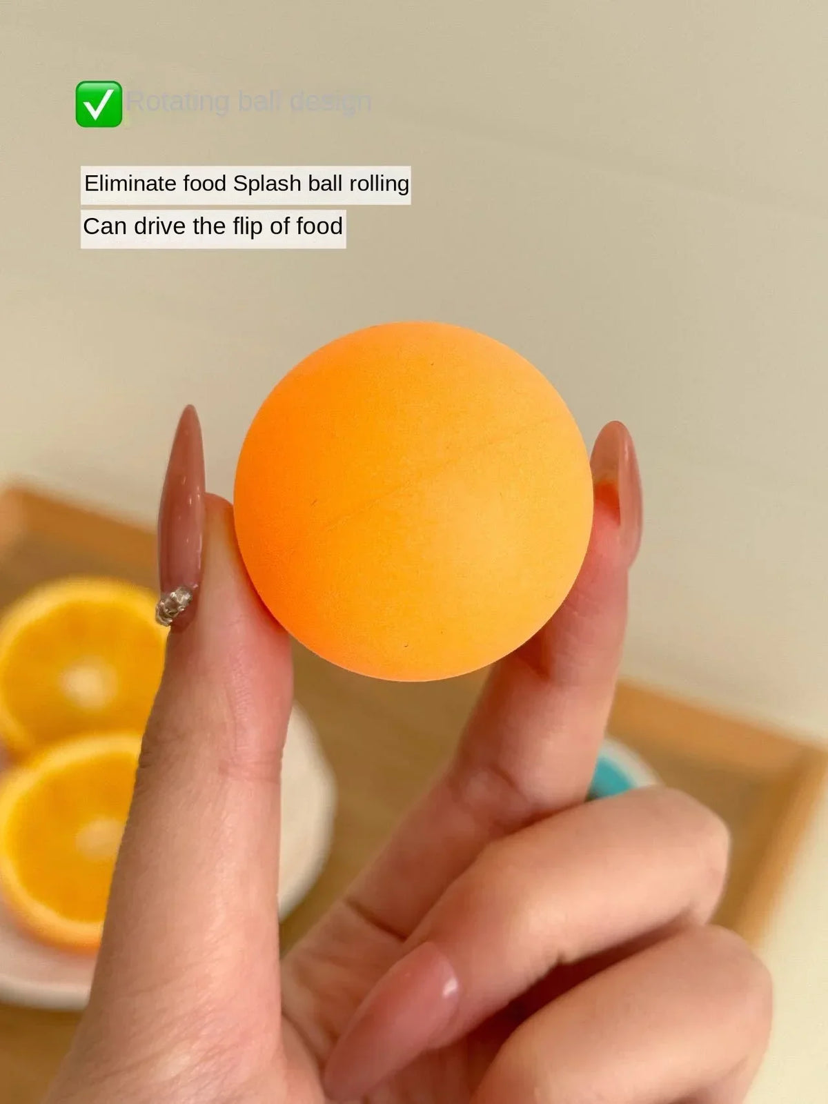 Eine Hand hält einen orangen, ballförmigen Spielzeug, das Spritzer verhindert und den Wurf von Essen auslöst.