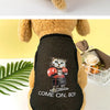 A fluffy dog wearing a black breathable mesh vest with a cartoon cat print and the text Come On Boy.