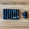 A row of sixteen black dog waste bags is displayed on a wooden surface next to a small black dispenser.