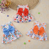 Une robe d'été colorée à motif floral et nœud orange, présentée sur un fond clair.