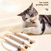 A tabby cat is using a natural silver vine cat tooth grinding stick for dental health.