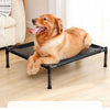 A golden retriever is relaxing on a black portable folding pet bed with a removable cover indoors.