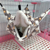 A cozy fleece double layer hammock bed for hamsters is shown inside a wire cage.