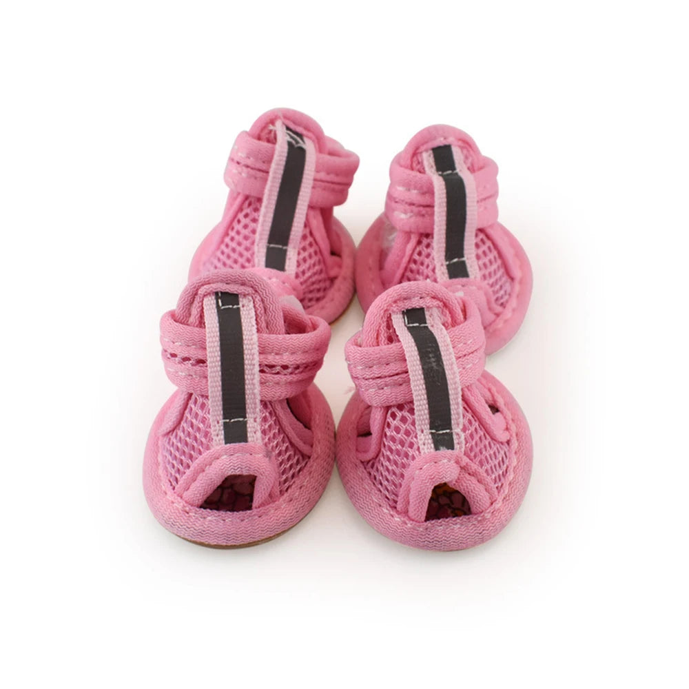 A pair of pink mesh dog and cat walking shoes with black accents.