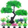 Colección de plantas acuáticas artificiales realistas en tonos verdes y rosas sobre un tronco de árbol oscuro.