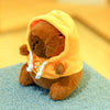 A brown capybara plush doll wearing a yellow hoodie with white trim and small wings.