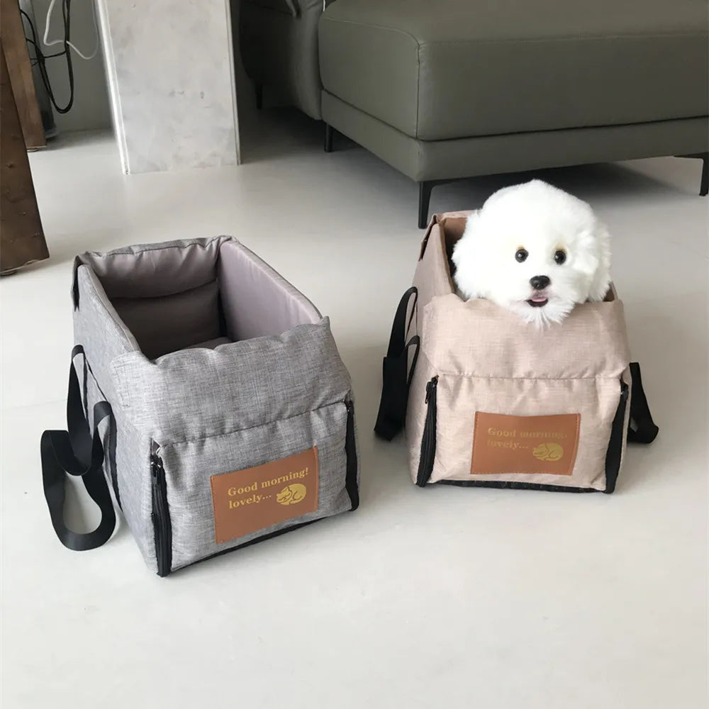 Helles graues, tragbares Transportgefäß für Haustiere mit weichem Innenfutter und einem kleinen weißen Hund.