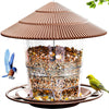 Wasserfester Vogelfuttermittelspender mit konischer Dachform, gefüllt mit Samen, auf einem braunen Tablett.