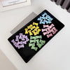 A black tray holds various bone-shaped hair clips in pastel colors for pet grooming.