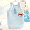 Light blue striped dog vest with a vintage tag and pearl necklace displayed on a white surface.
