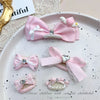 Pink bow pet hair clip with rhinestone and pearl accents displayed on a white plate.