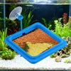 Un anneau d'alimentation bleu pour poissons d'aquarium est placé sur un substrat de gravier blanc dans un aquarium en verre.