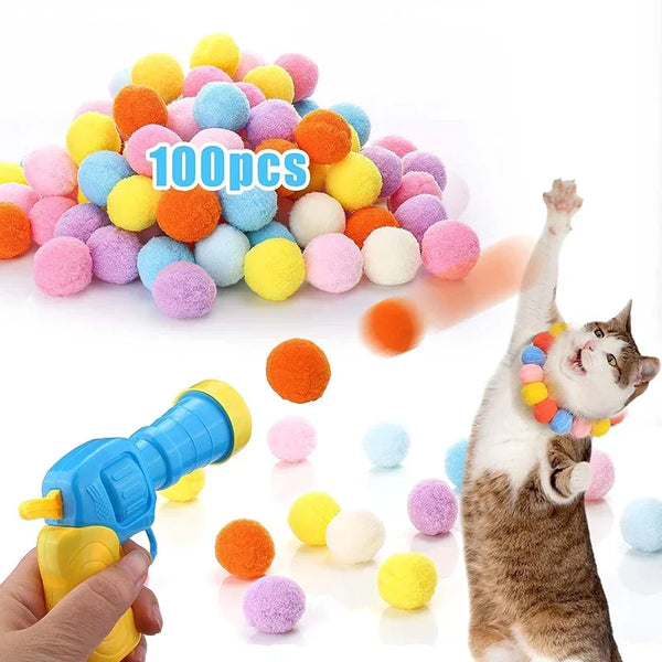 Eine Hand hält eine interaktive Plüschkatze-Waffe, umgeben von bunten, flauschigen Bällen.