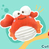 A collection of toys including a bouncing ball, crinkle paper, and a cute crab cover.