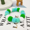 A colorful pet collar and bow tie set featuring bright green, blue, and white fuzzy textures.