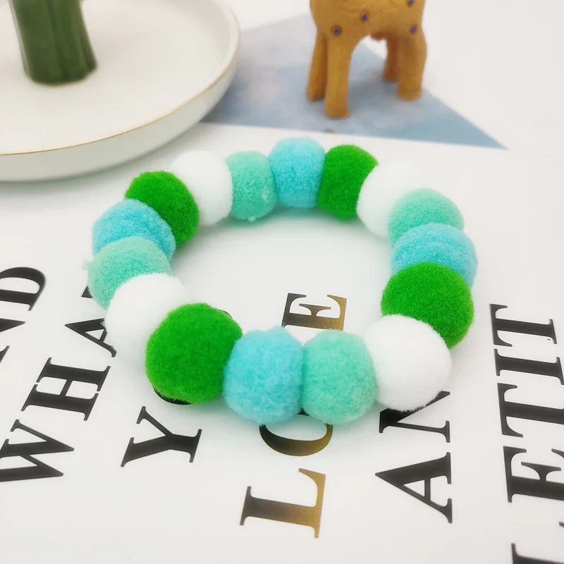 A colorful pet collar and bow tie set featuring bright green, blue, and white fuzzy textures.