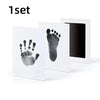 A set of white framed prints featuring black paw and hand prints for pet keepsakes.