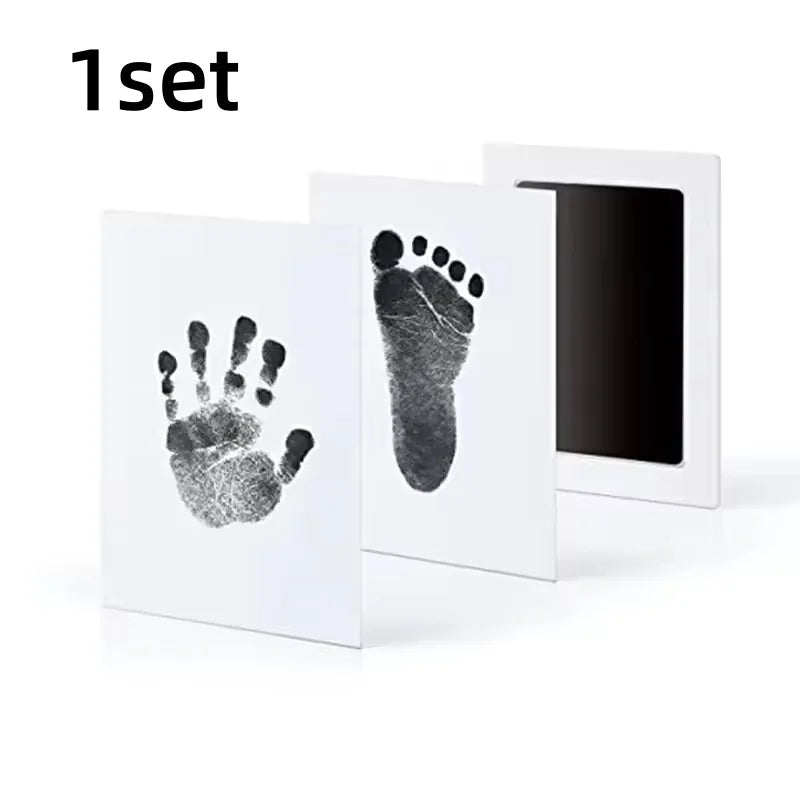 A set of white framed prints featuring black paw and hand prints for pet keepsakes.