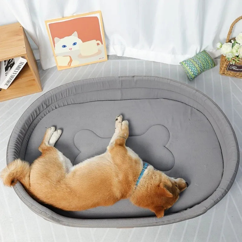 A fluffy orange dog is lying on a gray washable waterproof dog bed mat with a light-colored cat art print nearby.