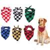 A dog wearing a red and black plaid bandana, surrounded by various plaid fabric bandanas.