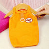 Orange knitted dog vest with a vintage tag hanging on a wooden hanger