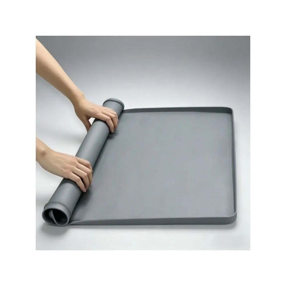 A hand is holding a gray silicone dog pee pad holder for indoor training.
