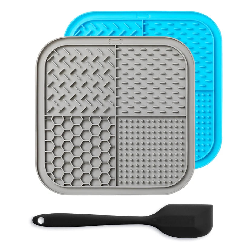 A gray silicone lick mat for pets is shown next to a blue silicone mat and a black silicone spoon.
