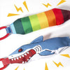 A colorful, striped rope toy shaped like a shark is shown against a white background.