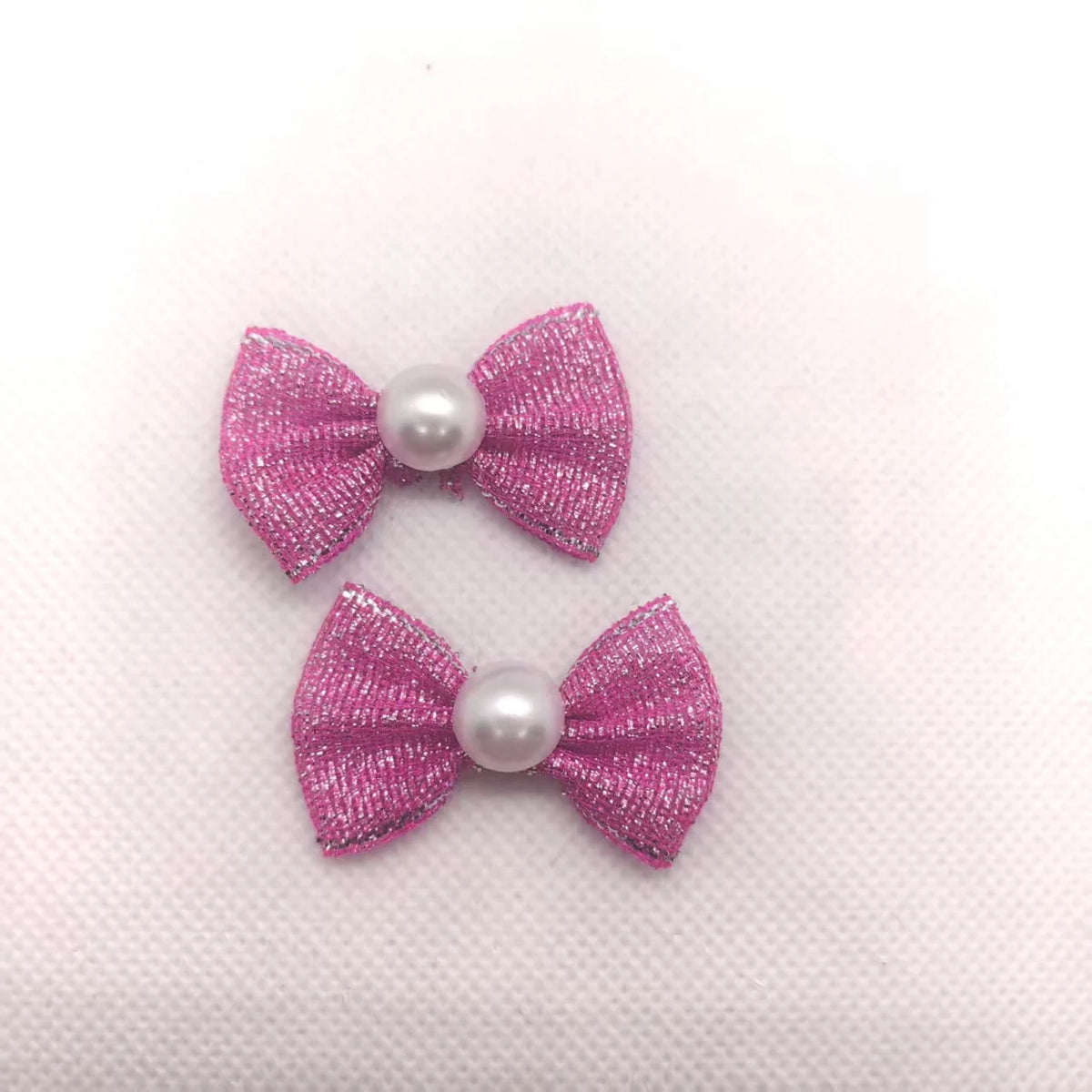 Ein Set aus drei rosa glitzernden Hundeknotenbändern mit Perlen-Akzenten für das Tiergrooming.