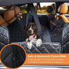 A dog is sitting in a black car seat cover designed as a safe and hammock convertible seat.