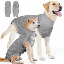 A golden retriever wearing a gray camouflage dog anxiety and recovery vest, with separate vest pieces shown.