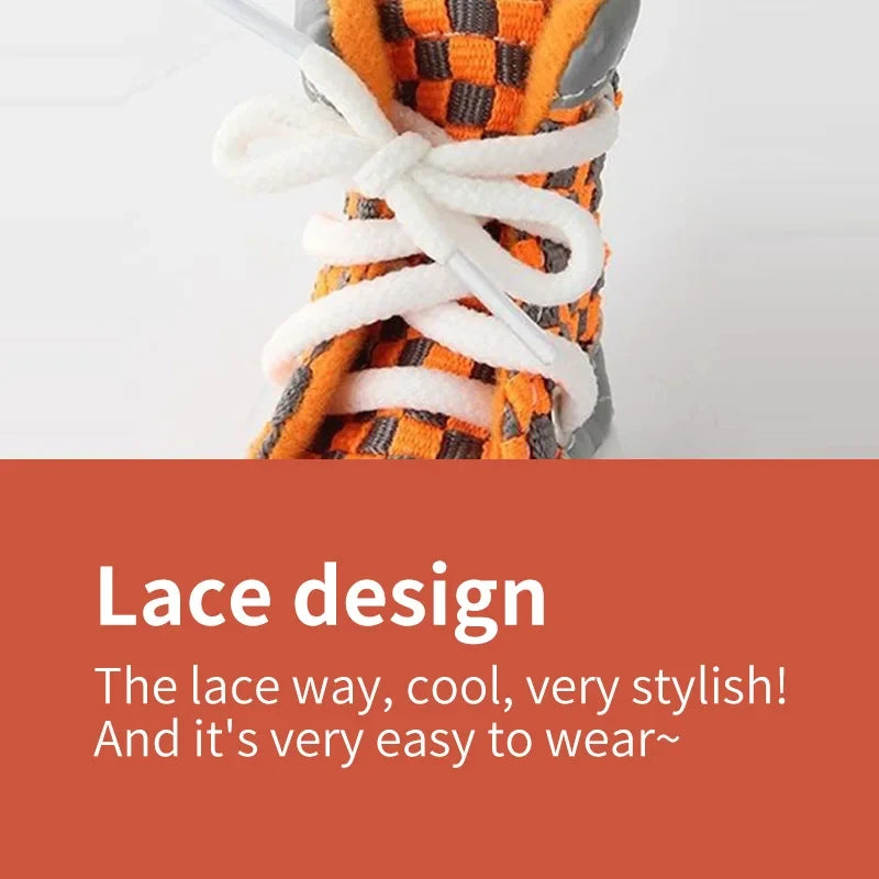 Close-up of a pair of orange and black woven laces tied on a shoe for a small dog.