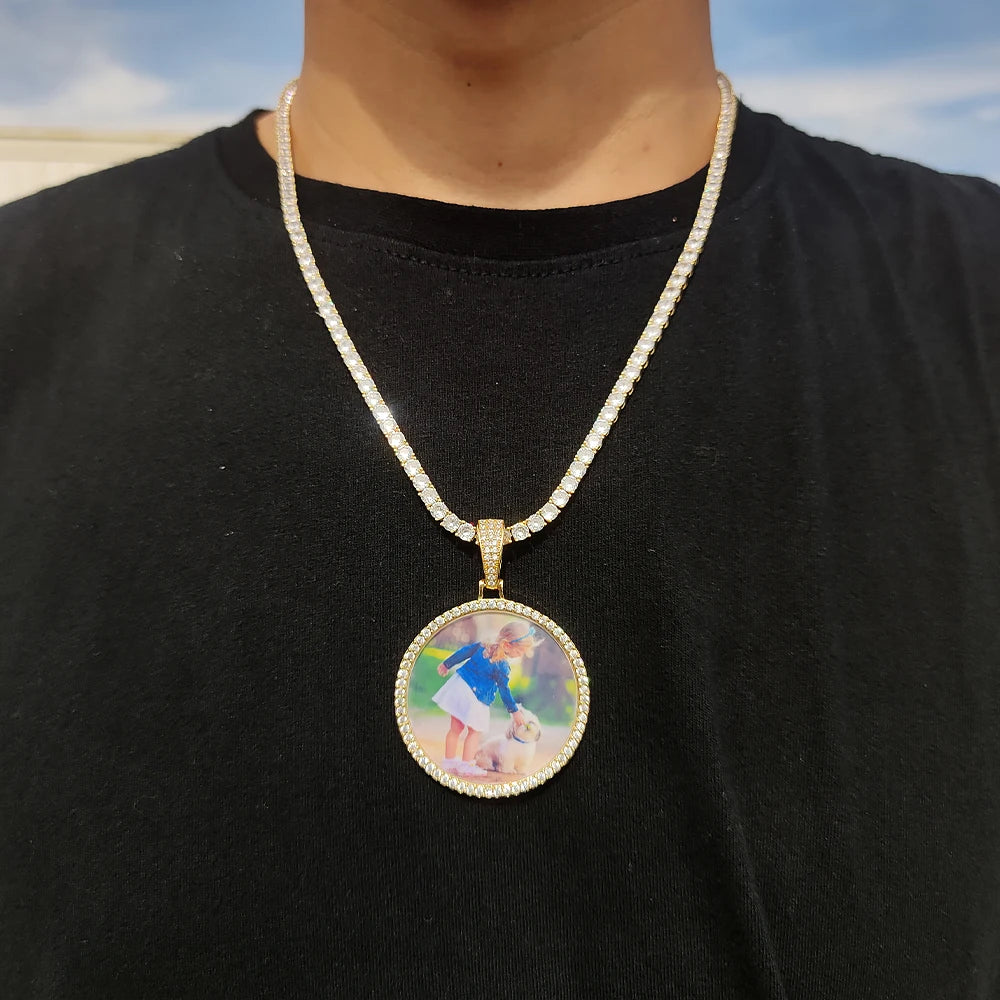 A custom photo pendant necklace with a gold finish is worn around the neck against a black shirt.