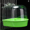 A clear plastic hanging bird bath with a green tray is suspended in a wire cage.