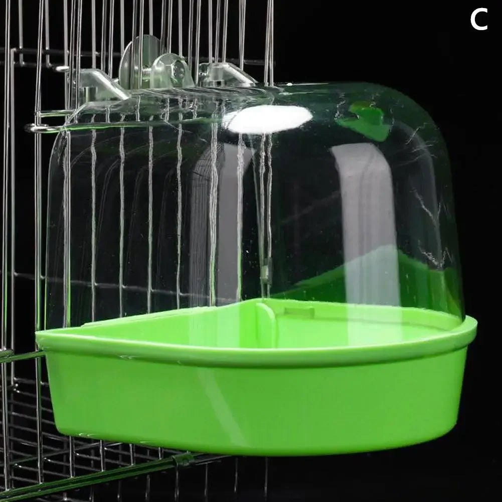 A clear plastic hanging bird bath with a green tray is suspended in a wire cage.