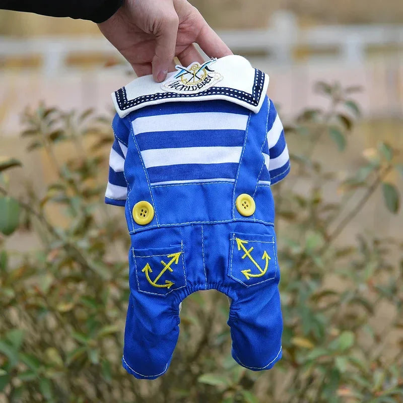 Traje de disfraz de perro con rayas azules y blancas temático de marinero, sostenido por una mano.