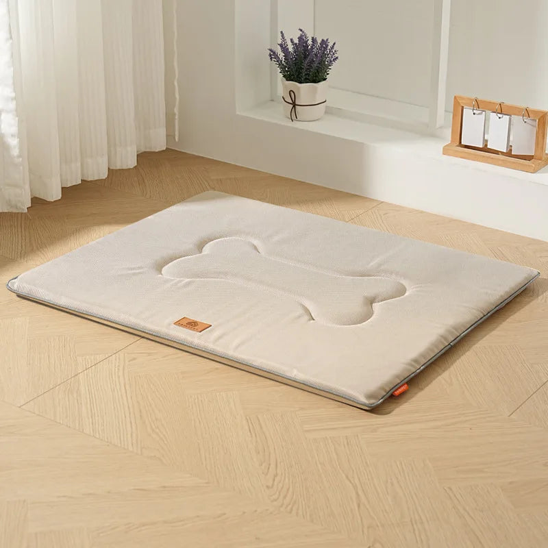 A beige waterproof dog bed mat with cushioned support placed on a light wooden floor.