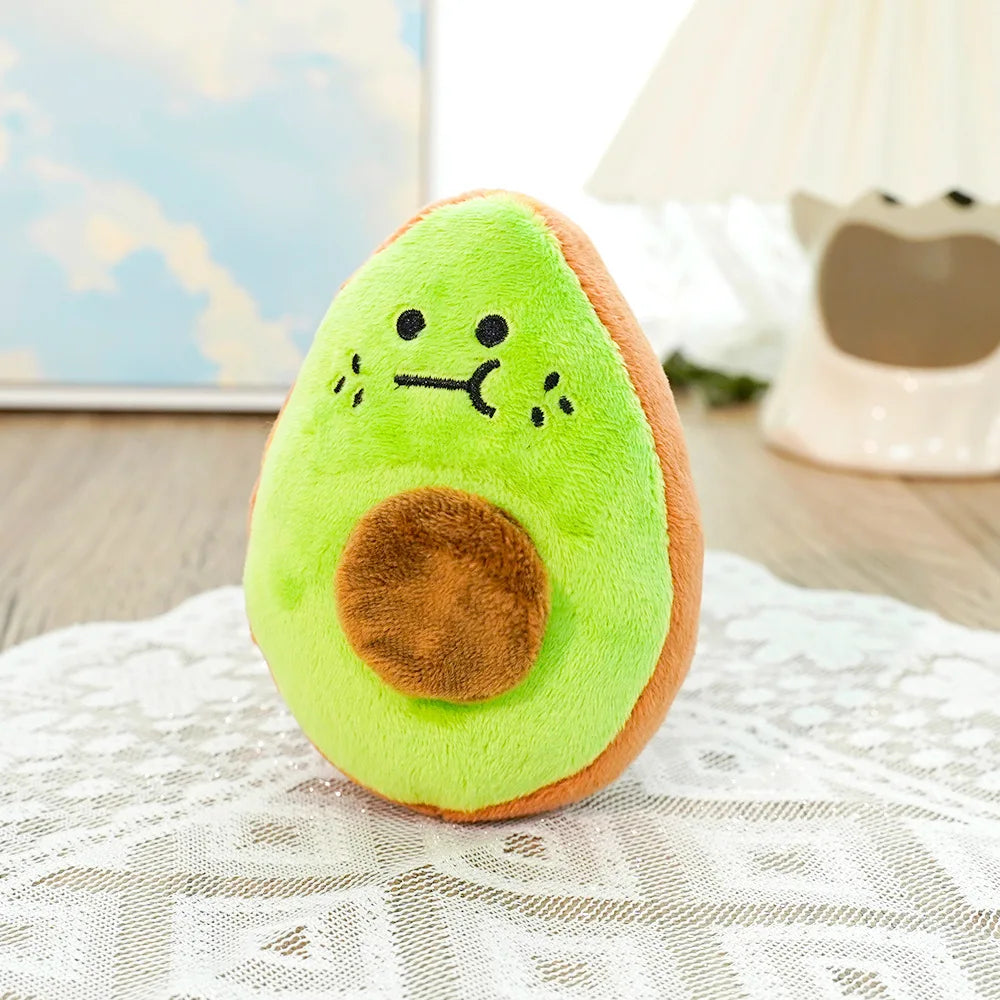 A bright green avocado plush toy with a brown center resting on a white lace cloth.