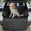 A golden retriever sits on a black waterproof dog car seat cover inside a vehicle.