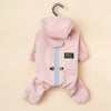 A pink waterproof reflective dog raincoat and jumpsuit with a hood and buttons.