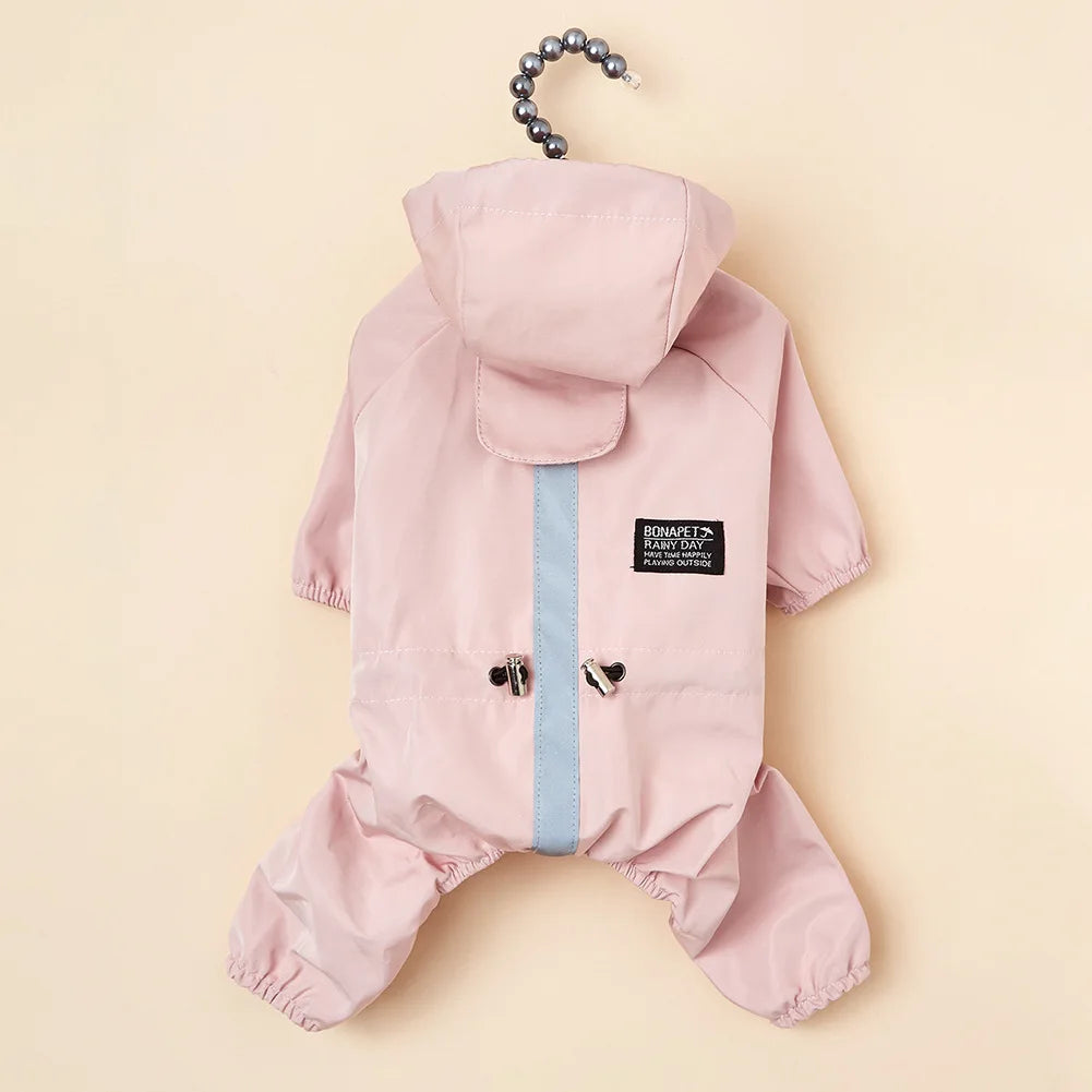 A pink waterproof reflective dog raincoat and jumpsuit with a hood and buttons.