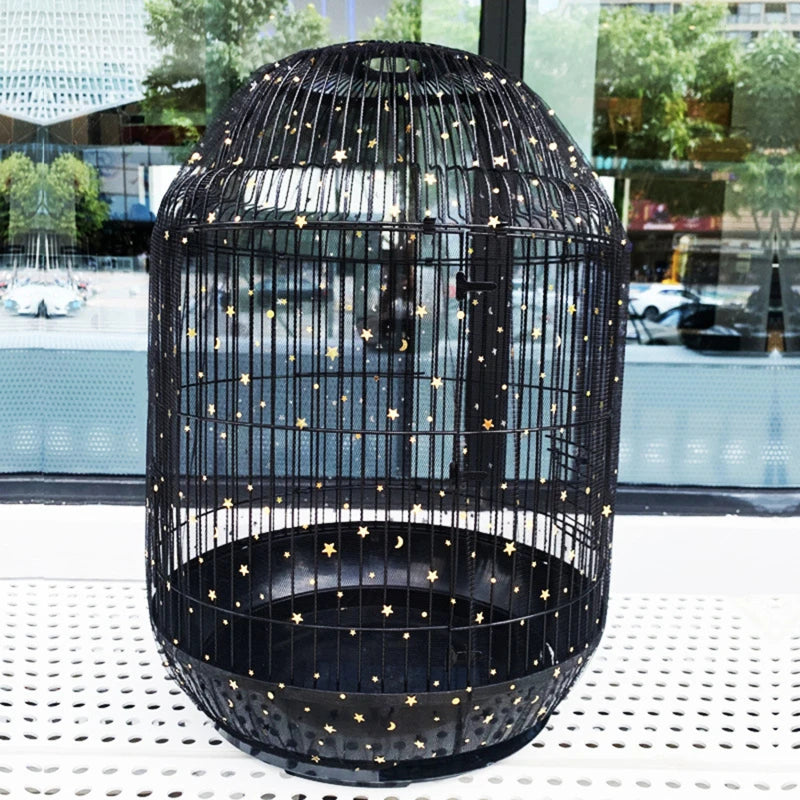 A black nylon mesh bird cage with gold stars decorating the sides and bottom, displayed on a white surface.