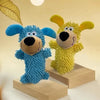 Two fluffy plush dogs, one blue and one yellow, sitting on wooden blocks.